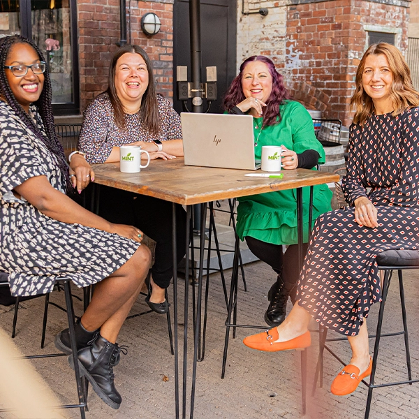 Team Photo of Mint HR Sat at Table with Laptop